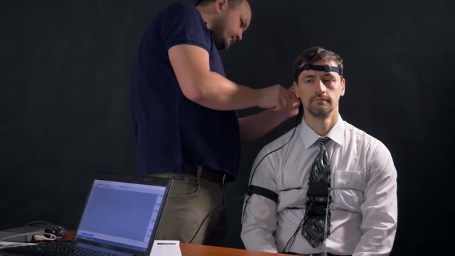 A man sitting and being prepared for polygraph test. 4k 60 fps.