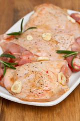 raw marinated chicken with smoked sausage on white dish