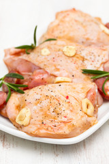 raw marinated chicken with smoked sausage on white dish