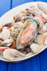 seafood in ice on dish on wooden background