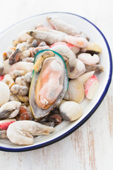 seafood in ice on dish on wooden background