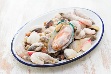 seafood in ice on dish on wooden background