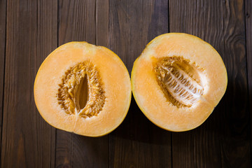 Melon cut in half on a wooden background (Top view)