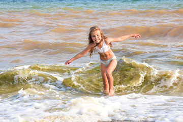 Fototapeta na wymiar улыбающийся ребенок играет в море