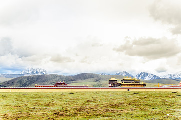 Fototapeta na wymiar Gyergo monastery and Mount Yala by tagong grassland in Sichuan province 