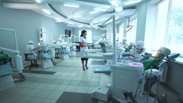 Students practicing dentistry on medical dummies in a teaching facility or university