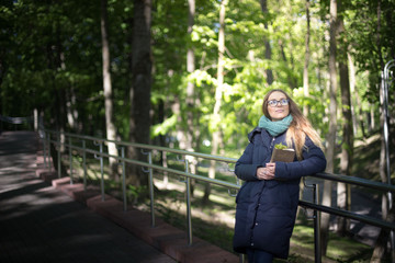 Happy girl reading a book at the railing.