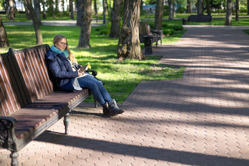 Girl reading a book in the park on the bench