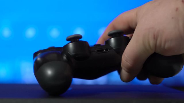 Gamer playing game on video gaming console with wireless controller
