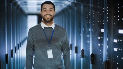 Portrait of an IT Engineer, he Smiles and Folds His Arms on a Chest. He's Working in Data Center...