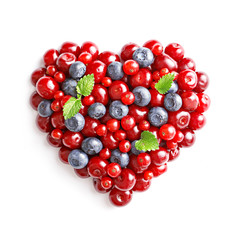Berries heart isolated on white background. Blueberries, sour cherries and red currants. Love and healthy life concept. Top view.
