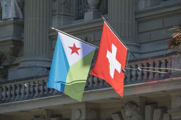 Nationalfahnen der Schweiz und von Dschibuti am Bundeshaus in Bern, Schweiz