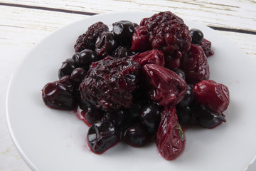 Strawberry,bluberry and cherry pickles on wooden background.