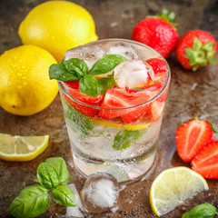Summer a refreshing lemonade. Drink with lemon, strawberries, mint, Basil and ice. Detox. Mineral water. Selective focus