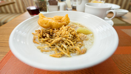 Rice gruel with fish fried, deep-fried doughstick and pork, delicious dish in the morning