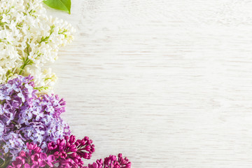 Obraz premium Colorful lilac flowers on the wooden table. Greeting card.