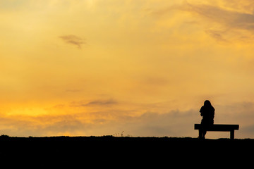 Fototapeta premium silhouette of woman relax on chair happy time sunset