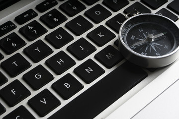 Compass on the black keybord with planning,strategic conceptual text. low light