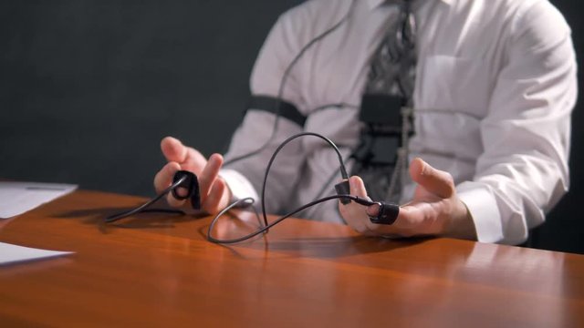 Male hands with lie detector sensors resting on a table. 4K 60 fps.
