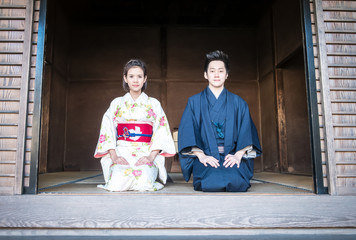 A man sit next to a woman with Kimono