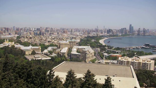 Panoramic view from above to the city of Baku, Azerbaijan. View from above on the embankment, the Caspian Sea, skyscrapers, high-rise buildings and the old city of Baku. Sunny day.