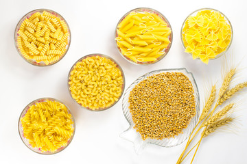 Five types of pasta in glass plates. Grains of wheat and wheat spikelets