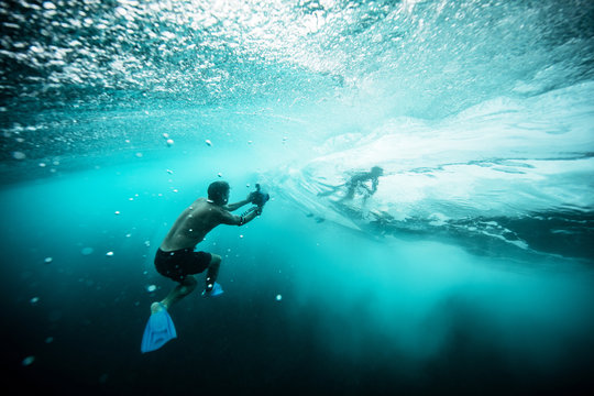 photographer underwater taking picture of surfer