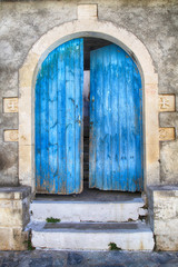 Old wall and blue wooden door, Greece