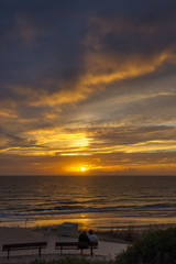 Ein Pärchen genießt den romantischen Sonnenuntergang an der Atlantikküste