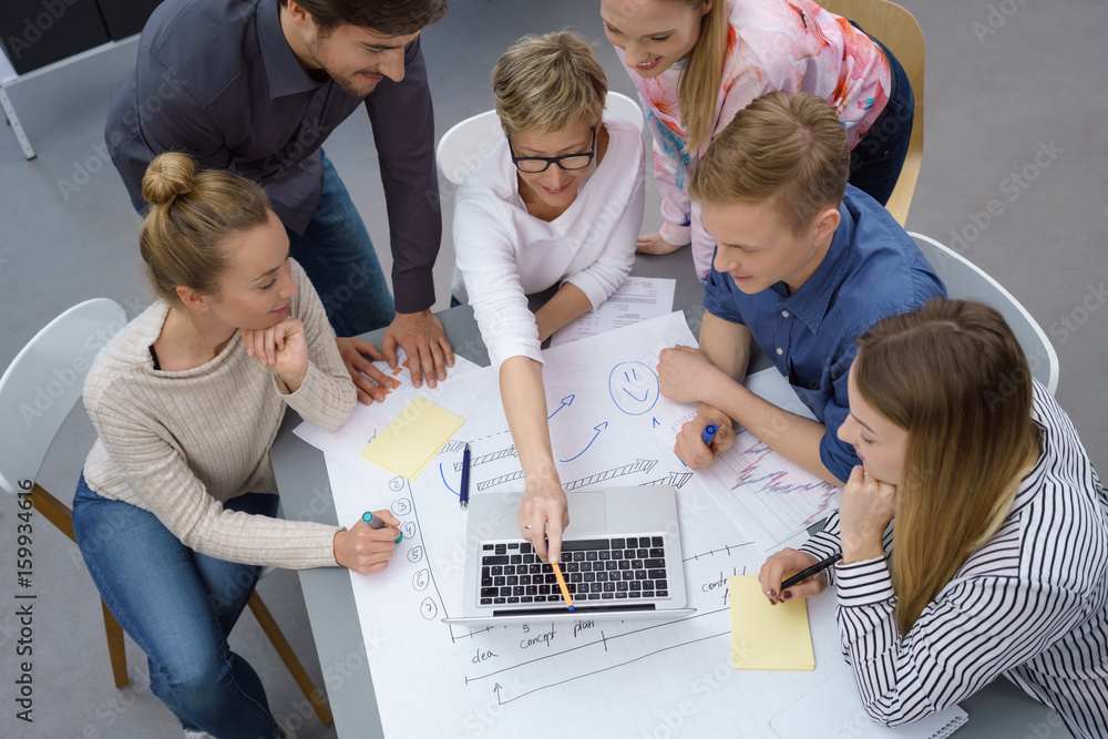 Poster motiviertes team schaut gemeinsam auf notebook und plant etwas