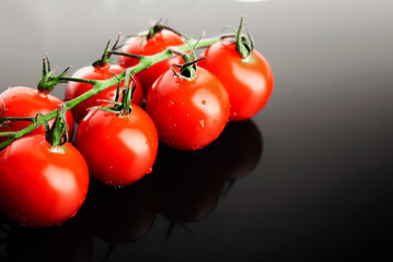 Fresh cherry tomatoes. At a background of gray gradient.