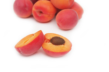 Albicocche intere e tagliate a metà isolate su
sfondo bianco. Fuoco selettivo.