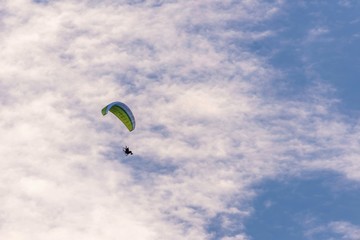 The paraglider with a green wing and motor on back