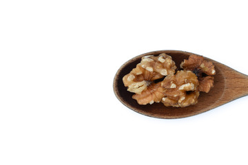 Walnut kernels in wooden spoon isolated on white background.