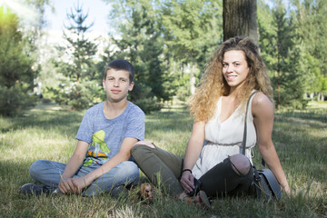 Fototapeta premium Brother and sister bonding at the park. Brother and sister having fun at the park. Smiling and looking at the camera.