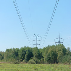 Electrical wires on steel supports. High-voltage power line over forest