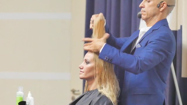 Hairdresser In Action. Barber and customers. hairstyle models for white hair. Blonde in the cabin. Work in the cabin. Barber shears white hair model client. close-up.