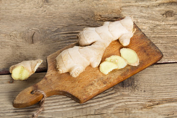 Raw ginger root on wooden background.