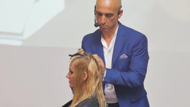 Hairdresser In Action. Barber and customers. hairstyle models for white hair. Blonde in the cabin. Work in the cabin. Barber shears white hair model client. close-up.