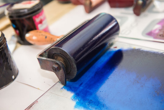 an acrylic paint roller for mono printing and screen printing, rolling paint ready for mono printing.