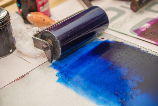 an acrylic paint roller for mono printing and screen printing, rolling paint ready for mono printing.