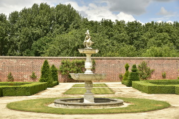 Obraz premium Fontaine rustique au milieu d'un cercle de pelouse au Jardin à la Française au domaine du château de Gaasbeek près de Bruxelles