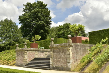 Fototapeta na wymiar L'escalier d'accès entre deux murs rustiques au Jardin à la Française du domaine du château de Gaasbeek près de Bruxelles