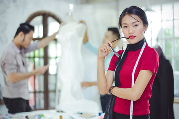 Designer pretty girls in casual clothes and hold the glasses are standing with arms, the cross,...
