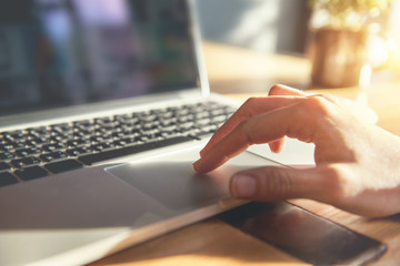 Woman hand using touchpad on laptop at home, she working on notebook. - obrazy, fototapety, plakaty