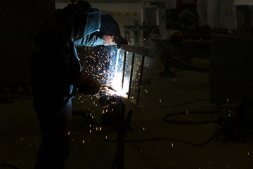 Anonymous labourer welding on iron