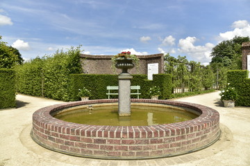 Pièce d'eau circulaire en maçonnerie à l'entrée de différentes sections des jardins du château de Gaasbeek près de Bruxelles 