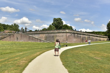 Femme solitaire devant les imposant murs des Jardins à la Française du château de Gaasbeek près de Bruxelles