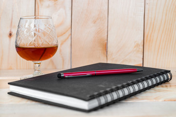 Whisky on black notebook on wood background,no idea,worry,serious