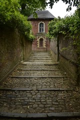 Obraz premium Chemin d'accès en gros pavés vers la petite chapelle du château de Gaasbeek ,près de Bruxelles